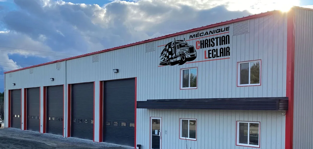 Le garage de la route 321, ses cinq grandes portes et l'enseigne Mécanique Christian Leclair